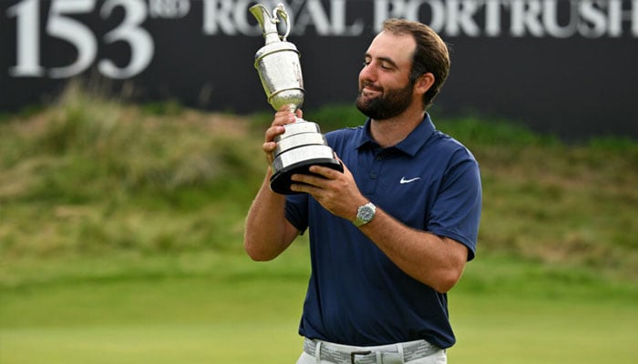 World number one Scottie Scheffler posing with the trophy. —AFP