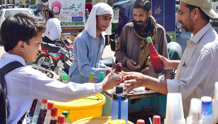 Students buying sweet crushed ice form a vendor during a hot day in Rawalpindi, on April 27, 2026. —  ONLINE