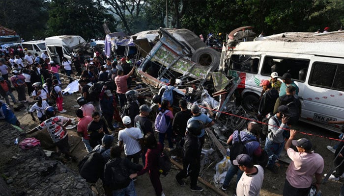 Rescue workers working on Colombian highway bombing site. —AFP