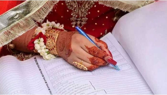 A representational image showing a bride signing Nikah papers. — X@iris_petal_dew/File
