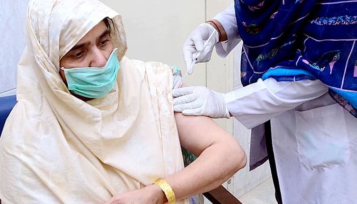 A health worker administering coronavirus vaccine to a senior citizen at the vaccination centre at Latifabad on April 15, 2021. — APP/File