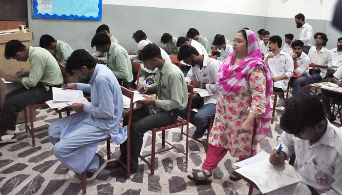 Intermediate students appear in examinations as invigilators monitor the examination process at a centre in Karachi, on April 29, 2026. — APP