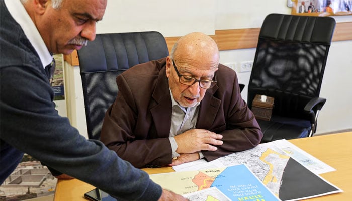 The Director General of the Applied Research Institute-Jerusalem (ARIJ), Dr. Jad Isaac, looks at maps of Gaza during an interview with Reuters in Bethlehem, in the Israeli-occupied West Bank, April 28, 2026.—Reuters