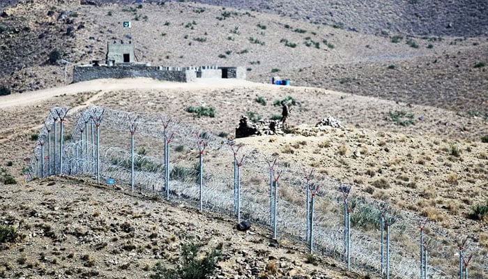 A Pakistani soldier keeps vigil beside a newly fenced border fencing along the Afghan border at Kitton Orchard Post in Pakistans North Waziristan tribal agency on October 18, 2017. — AFP