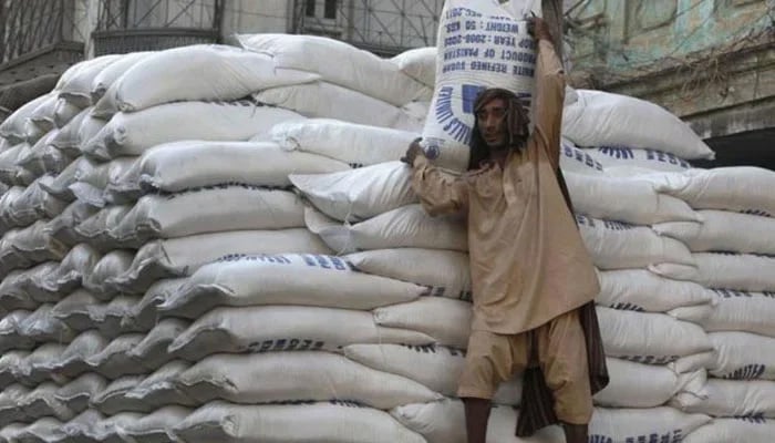 A man can be seen off-loading sugar backs from a truck. —AFP/File