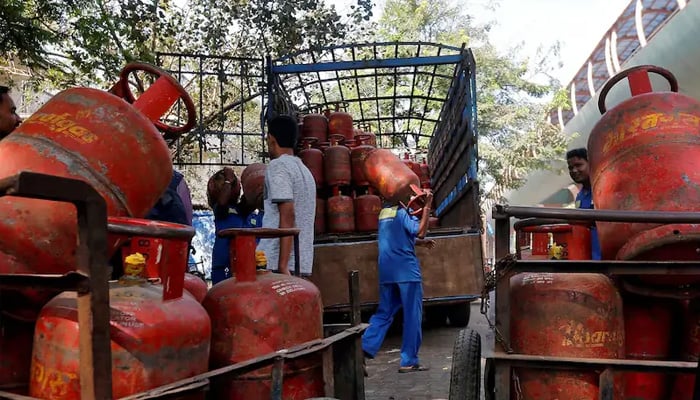 Workers load liquefied petroleum gas (LPG) cylinders onto a supply truck outside a distribution centre in Mumbai, India. — Reuters/File