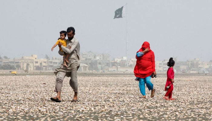 A family walk along the beach on a hot day in Karachi, Pakistan, in May 2016. — Reuters