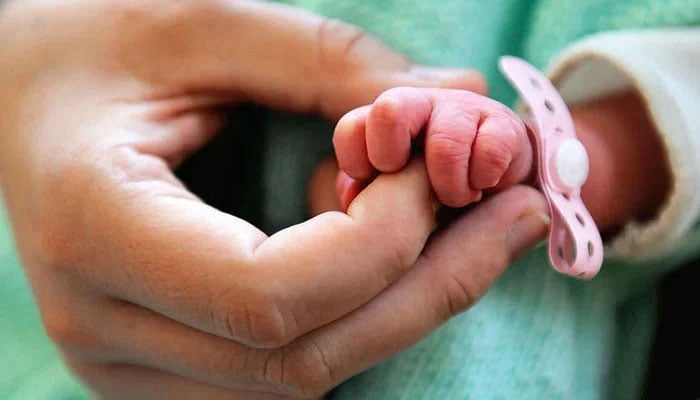 The representational image features a newborn babys hand being held by mother. — AFP/File