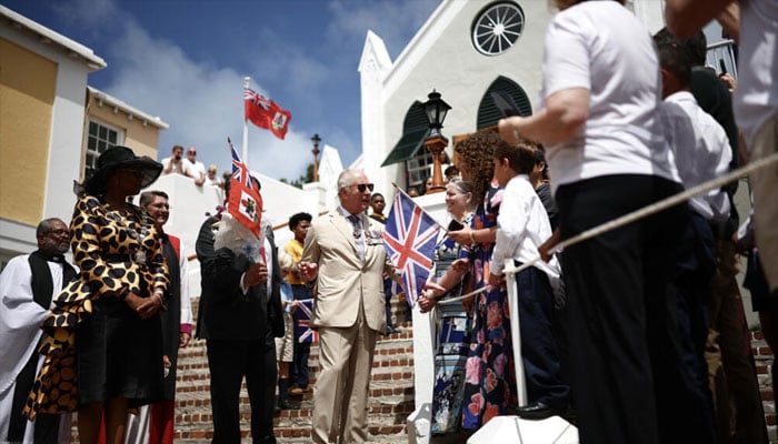 King Charles greeted a line of schoolchildren, pausing to chat with them, on the steps of the whitewashed St. Peters Church.—AFP