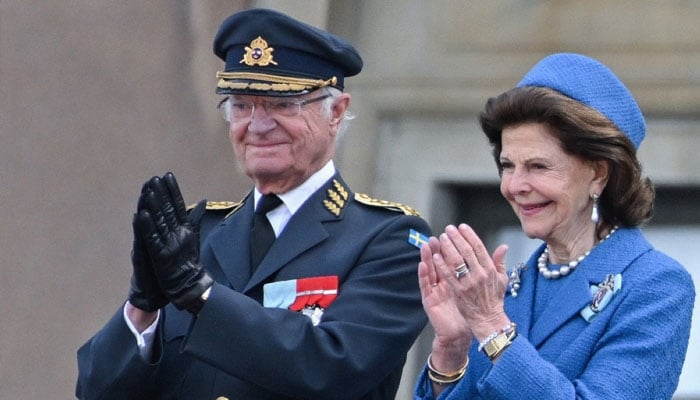 Swedens King Carl XVI Gustaf (left) and Swedens Queen Silvia applaud from the balcony as members of the Swedish Armed Forces pay tribute to the King at the Outer Courtyard of the Royal Palace in Stockholm, Sweden, on April 30, 2026.— AFP