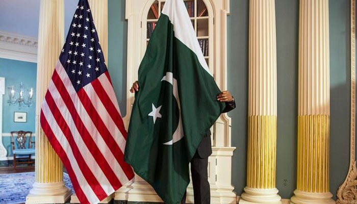 A State Department contractor adjusts a Pakistan national flag before a meeting between US and Pakistani officials in Washington February 19, 2015. — Reuters