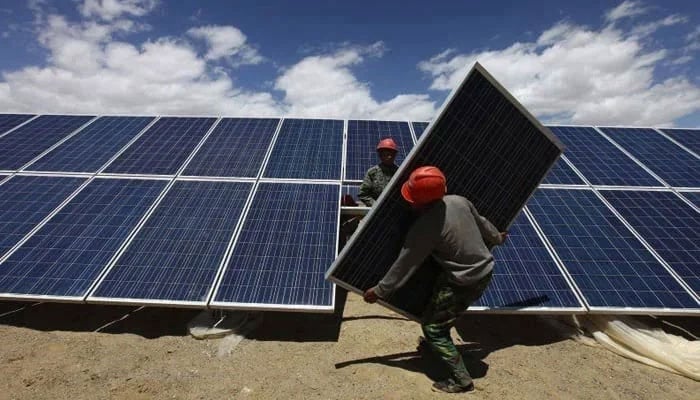 This representational image shows workers installing a solar panel. — Reuters/File