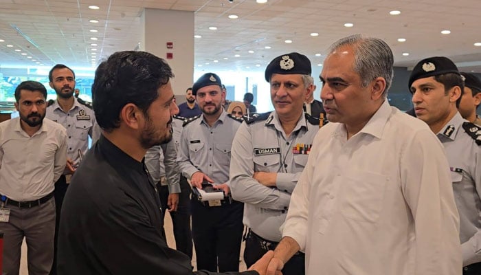 Interior Minister Mohsin Naqvi interacts with a pilgrim during a visit to the Islamabad International Airport on May 7, 2026. — Facebook@Ministry of Interior GoP