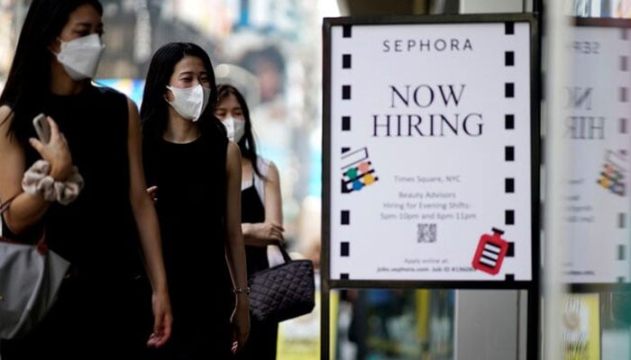 A sign advertising job openings is seen while people walk into the store in New York City, New York, US, August 6, 2021. — Reuters