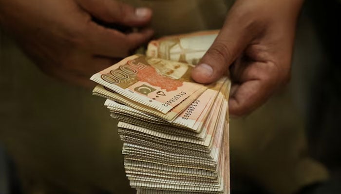 A trader counts Pakistani rupee notes at a currency exchange booth in Peshawar, Pakistan, July 29,2025. — Reuters