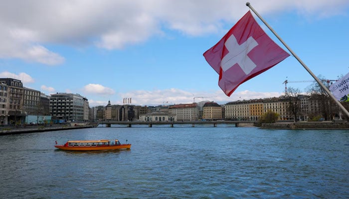A Swiss flag and a mouette boat, as seen from the Mont Blanc bridge, in Geneva, Switzerland, March 18, 2026. — Reuters