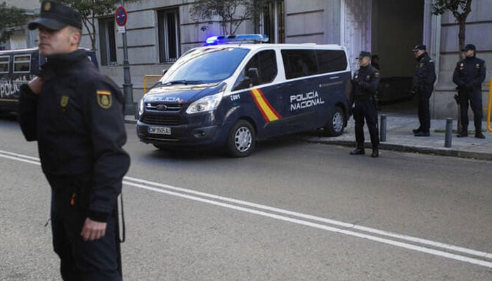 This image depicts Spanish Policía Nacional officers and a police van. — AFP/File