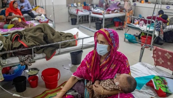 A woman holds a child diagnosed with measles inside a paediatric ward at the Bangladesh Shishu Hospital and Institute in Dhaka on May 6, 2026. — AFP