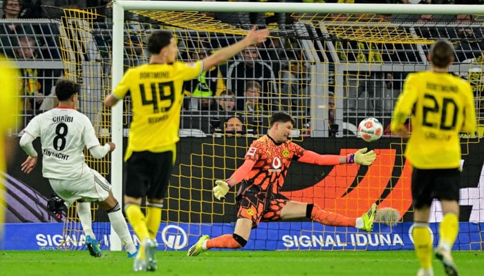 Frankfurts Algerian midfielder Fares Chaibi (left) scores an offside goal past Dortmunds Swiss goalkeeper Gregor Kobel during the German first division Bundesliga football match between BVB Borussia Dortmund and Eintracht Frankfurt in Dortmund, western Germany. —AFP