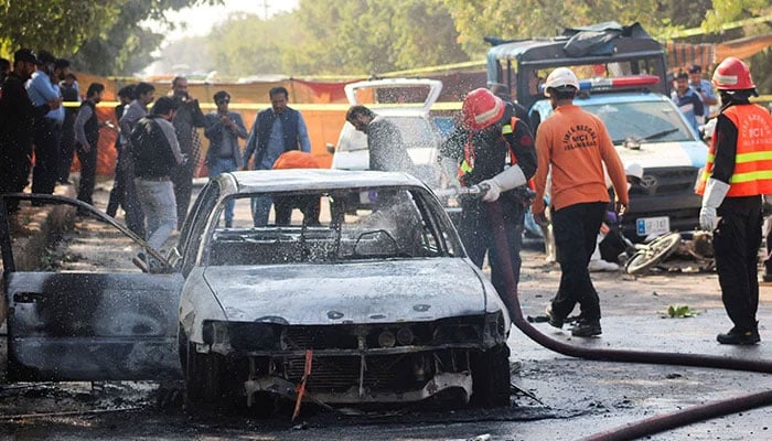 A representational image showing firefighters dousing a vehicle after a blast outside a court building in Islamabad, November 11, 2025. — Reuters