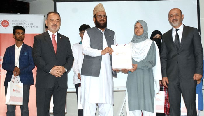 Federal Minister for Religious Affairs and Interfaith Harmony, Sardar Muhammad Yousaf along with Ambassador of Türkiye to Pakistan Dr Irfan Neziroglu, awards a prize to the winner of the National Essay Writing Competition 2026 on May 11, 2026. — Online