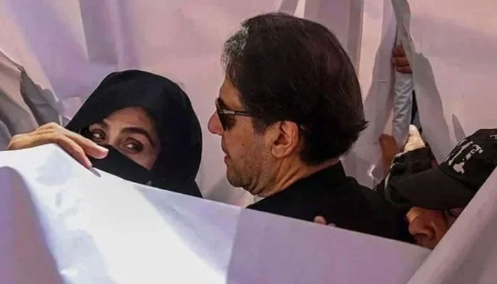 PTI founder Imran Khan with his wife Bushra Bibi arrive to appear in a high court in Lahore on May 15, 2023. — AFP