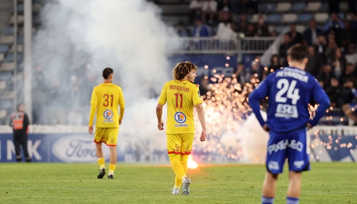 Smoke rises after lit flares were launched on the pitch by Bastia fans during a French Ligue 2 match against Le Mans. —AFP