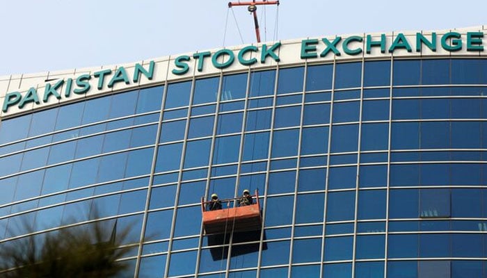 Workers clean a glass facade of the Pakistan Stock Exchange (PSX) building in Islamabad, Pakistan December 3, 2018. — Reuters