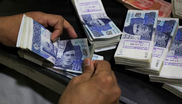 An employee counts Pakistani rupee notes at a bank in Peshawar, Pakistan August 22, 2023. — Reuters