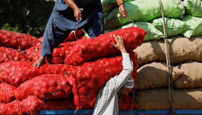 Labourers unload sacks of onion from a truck to supply at a market in Karachi, Pakistan February 1, 2023. — Reuters
