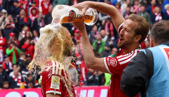 Harry Kane celebrates the Bundesliga success after victory over Cologne. —AFP/File