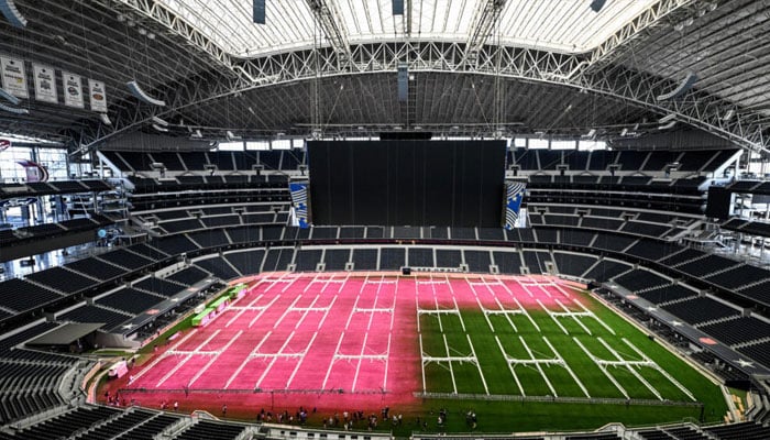 Pink grow lights designed to encourage photosynthesis flood a newly laid grass field at the AT&T Stadium in Texas, where World Cup matches will be held. —AFP/File