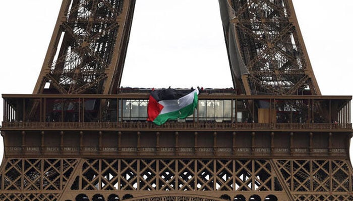 People flying a Palestinian flag from the Eiffel Tower. —Reuters