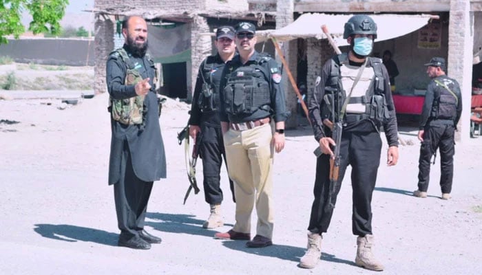 KP police personnel stand guard on the road on May 6, 2024. — Facebook@Bannu Police