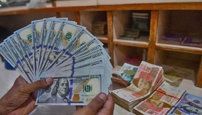 A foreign currency dealer counts US dollars at a shop in Karachi, Pakistan, on May 19, 2022. — AFP/File