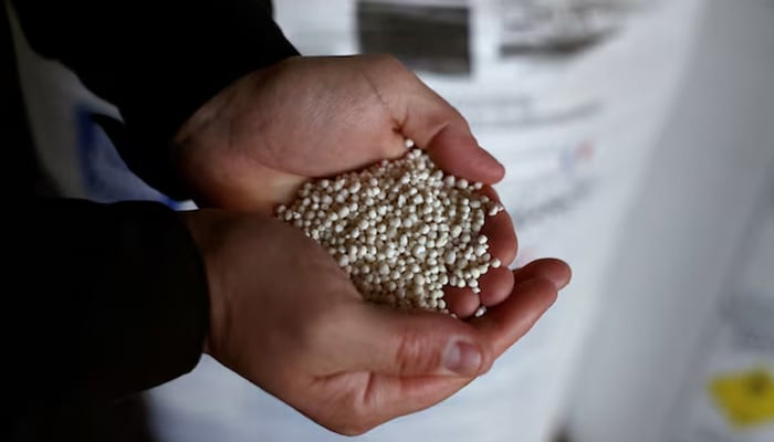 French farmer holds nitrogen fertilisers white pellets in his hands in his farm in Arville, France, May 7, 2026. — Reuters