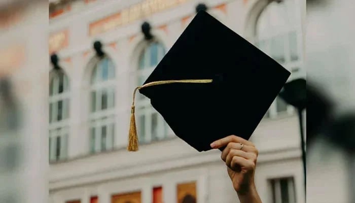 This representational image shows an individual holding a graduation cap. — Unsplash/File