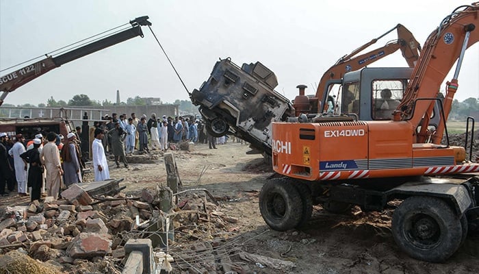 A crane removes a burned armored vehicle from a damaged police checkpost site following a car bombing attack by militants in the Fateh Khel area of Bannu, Khyber Pakhtunkhwa, on May 10, 2026. — AFP