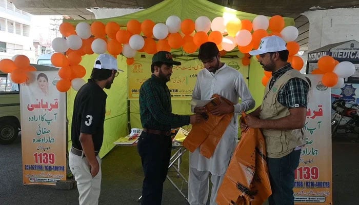 The RWMC team distributes biodegradable bags and pamphlets to create awareness among the people at a camp on June 9, 2024. — Facebook@RWMCPindi