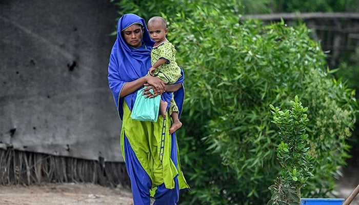 This photograph taken on July 29, 2025 shows a pregnant woman arriving with her child to attend the UNICEF nutrition programme at Fateh Muhammad Soomro village in the Sujawal district of Sindh. — AFP