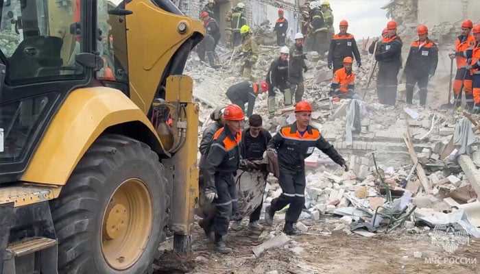 Rescue workers working at the site of the strike. —AFP