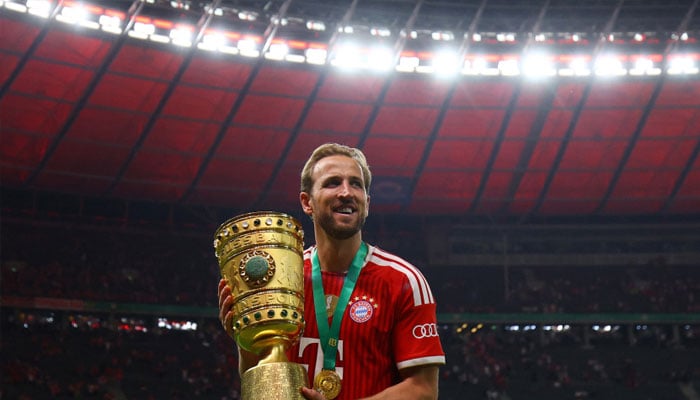 Bayern Munichs Harry Kane holds the trophy as he celebrates winning the DFB Cup.—Reuters