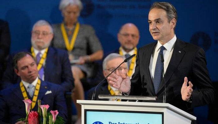 Greek Prime Minister Kyriakos Mitsotakis (right) gives a speech during a ceremony. —AFP/File