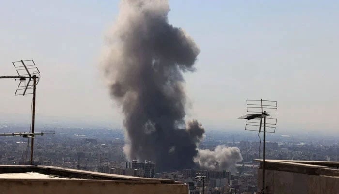 A plume of smoke rises following reported explosions in Tehran on March 1, 2026. — AFP
