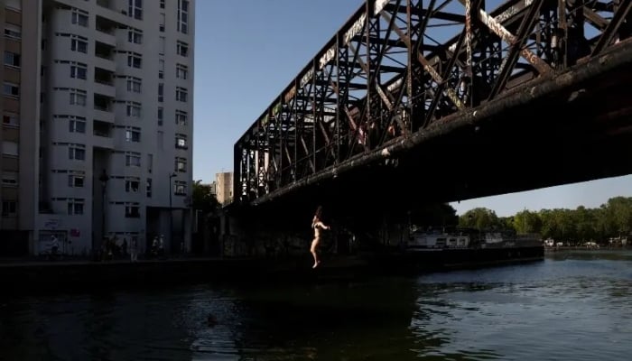 A person jumps off a bridge into the Canal de lOurcq, as temperatures reached up to 35°C, during a period of hot weather in Paris, France on May 25, 2026. —Reuters