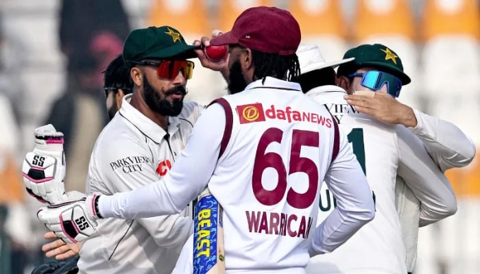 Pakistans Sajid Khan (left) shakes hands with Jomel Warrican after winning the first Test cricket match against West Indies at the Multan Cricket Stadium in Multan on January 19, 2025. — AFP