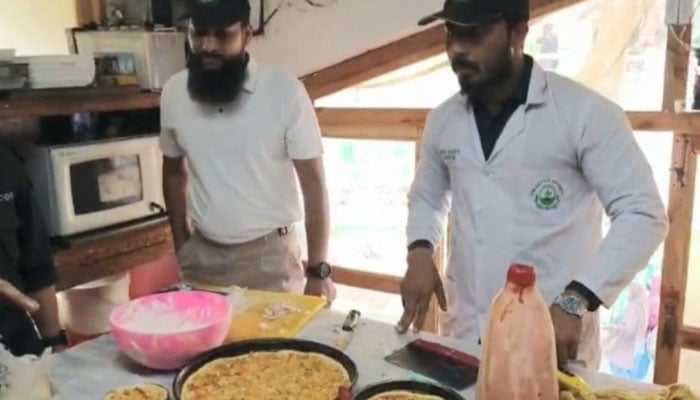 This image shows officials of the food authority inspecting standard and substandard food items. — APP/File