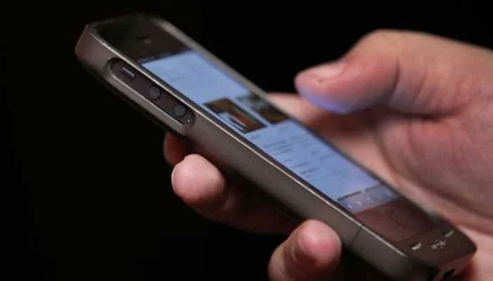 A representational image showing a person holding a mobile phone. — Reuters/File