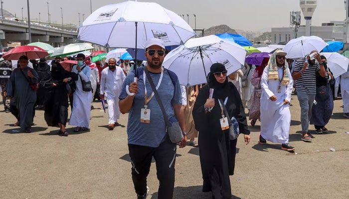 Muslim pilgrims holding umbrellas walk on the third day of the Satan stoning ritual, amid extremely hot weather, during the annual haj pilgrimage, in Mina, Saudi Arabia, June 18, 2024. — Reuters