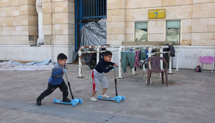 Children play outside Camille Chamoun Sports City stadium, turned into a temporary shelter in Beirut, Lebanon, May 8, 2026. — Reuters